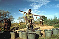 Women at work : collecting water from open well.