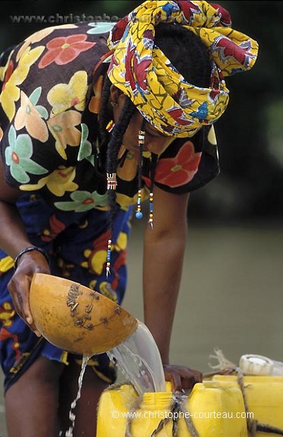 Jeune femme, Ethnie Peul, en train de remplir des bidons d'eau. Niger.