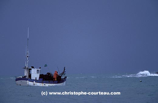 Bateau de pêche artisanale. Remontée des casiers à crustacés sous l'orage.